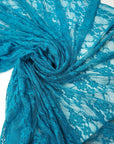 Turquoise teal floral stretch lace fabric draped and swirled showing vibrant color