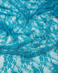 Turquoise teal floral stretch lace fabric draped with soft folds and floral pattern