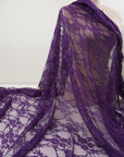 Deep eggplant purple floral stretch lace fabric draped on mannequin showing drape