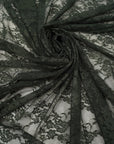Hunter green floral stretch lace fabric draped and folded showing deep forest green color