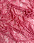 Coral vintage floral stretch lace fabric close-up draped showing vibrant color