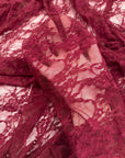 Close up burgundy lace fabric intricate floral pattern sheer draped