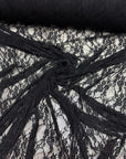 Black floral lace fabric draped showing intricate floral pattern