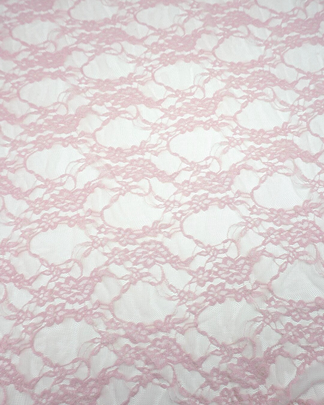 Blush pink floral stretch lace fabric semi-transparent close-up repeating floral design