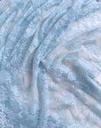 Baby Blue Floral Stretch Lace Fabric draped in soft pastel blue folds