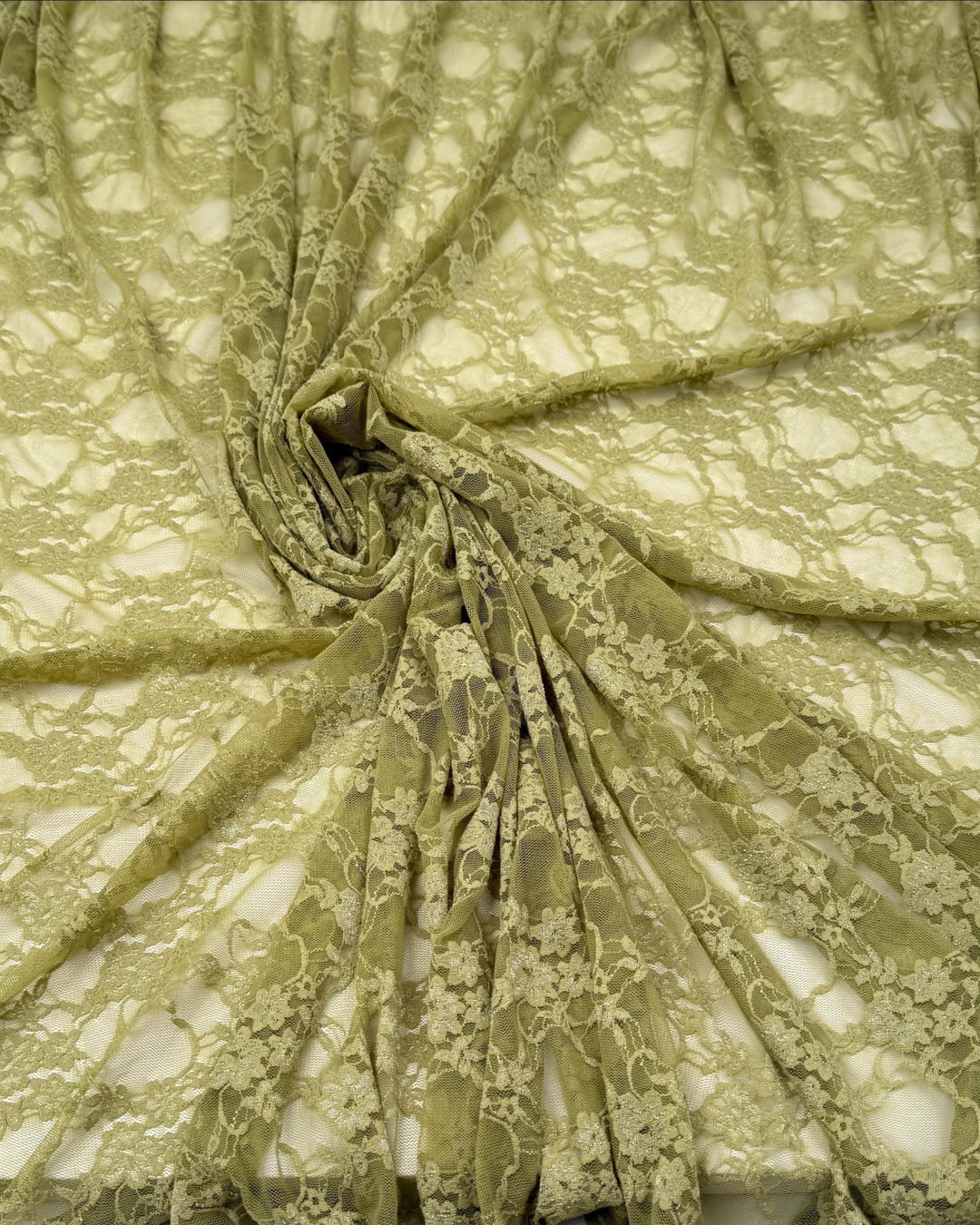 Moss green floral stretch lace fabric draped flat showing texture and open weave