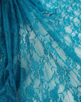 Flowing turquoise teal floral stretch lace fabric semi-transparent close-up