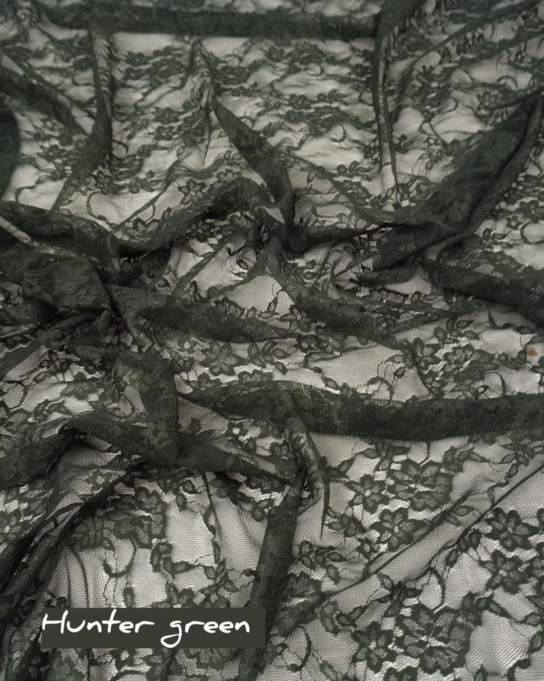 Hunter green floral stretch lace fabric draped showing deep green color