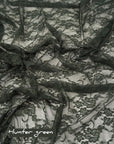 Hunter green floral stretch lace fabric draped showing deep green color