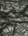 Hunter green floral stretch lace fabric draped with hunter green label