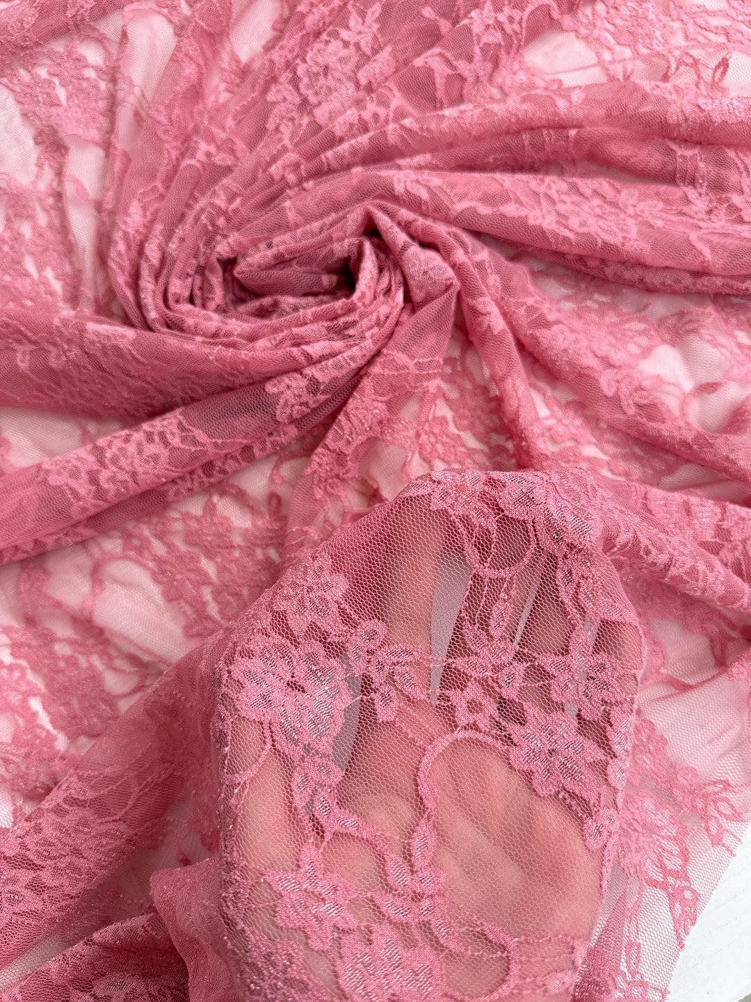 Coral dusty rose floral stretch lace fabric gathered showing delicate pattern