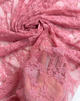 Coral dusty rose floral stretch lace fabric gathered showing delicate pattern