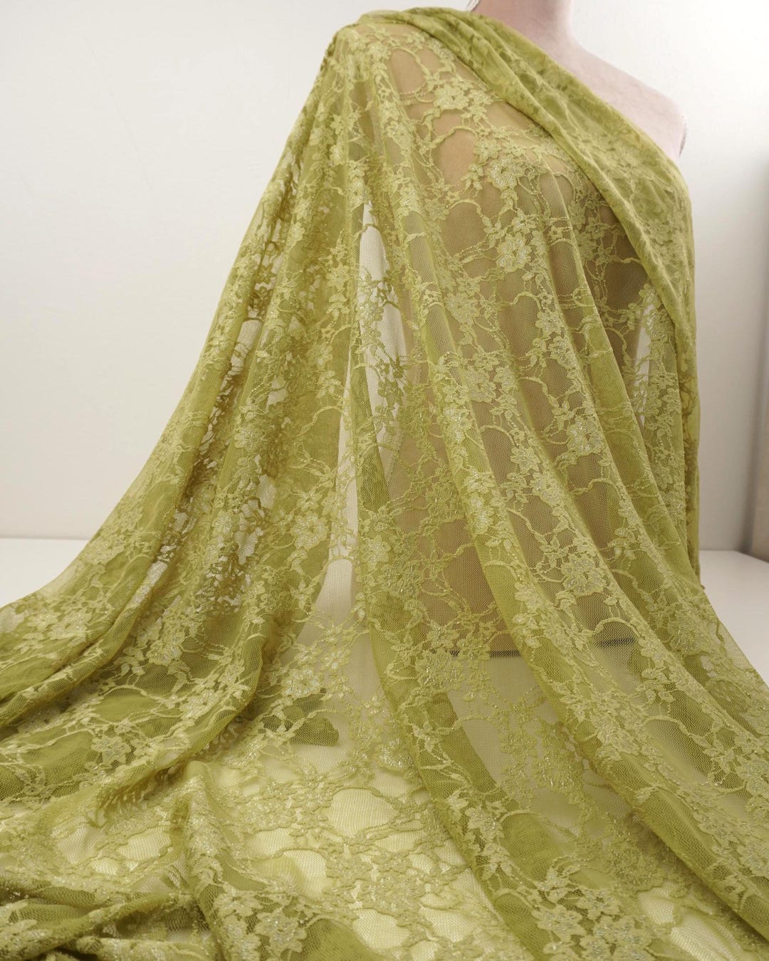 Moss green floral stretch lace fabric draped on mannequin, 4-way stretch vintage style