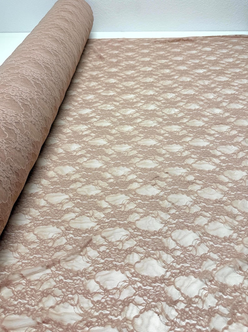 Nude Floral Stretch Lace Fabric partially rolled up showing openwork pattern