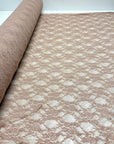 Nude Floral Stretch Lace Fabric partially rolled up showing openwork pattern