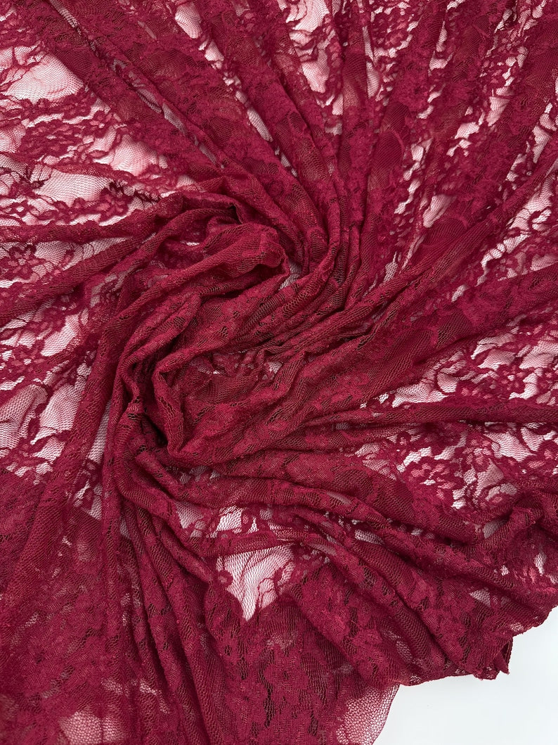 Close up deep burgundy lace fabric gathered drape showing intricate floral details