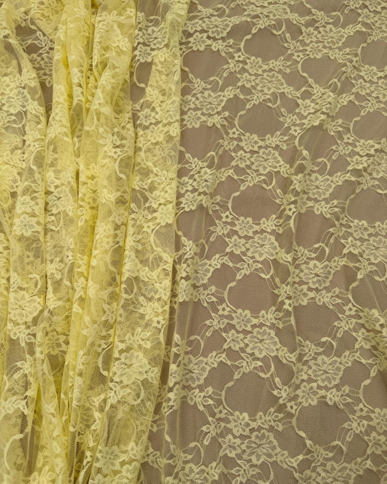 Close up of pale yellow floral lace fabric showing texture and transparency