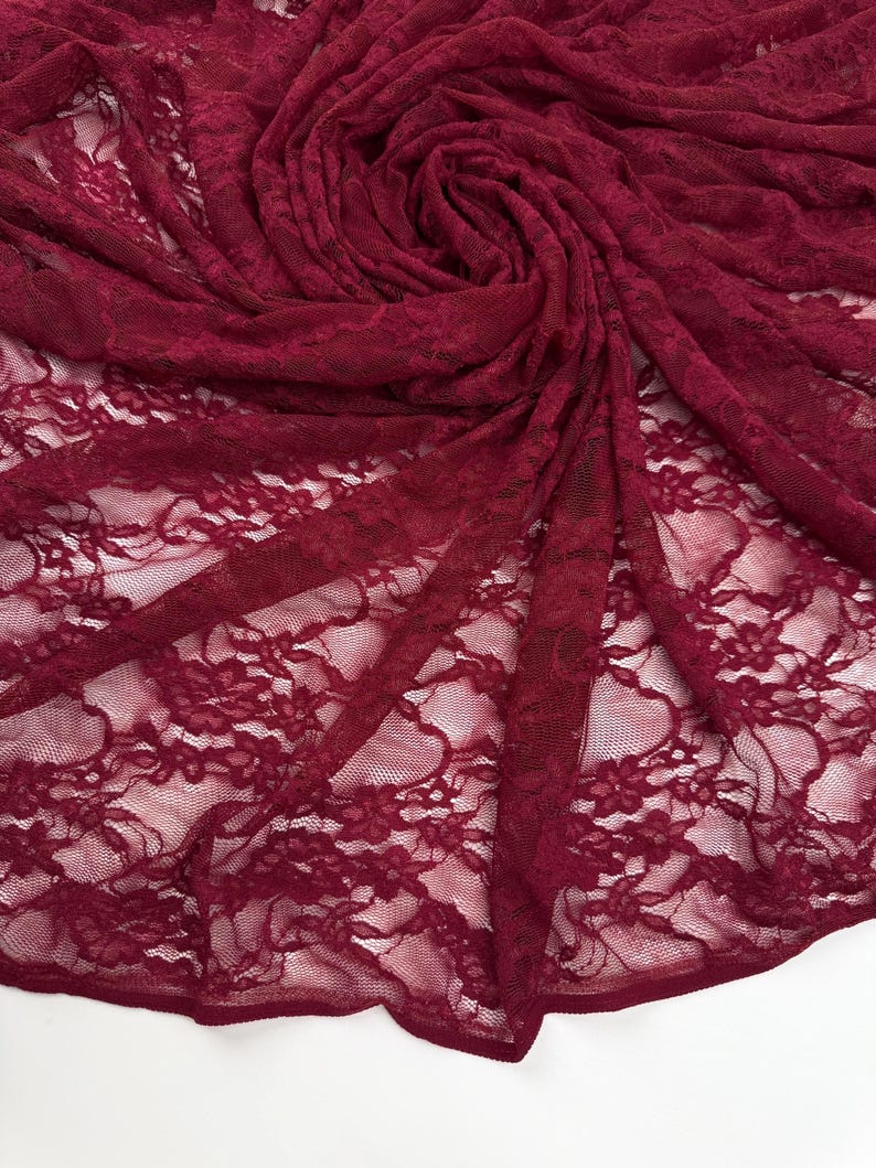 Burgundy Floral Stretch Lace Fabric draped and swirled showing deep red texture