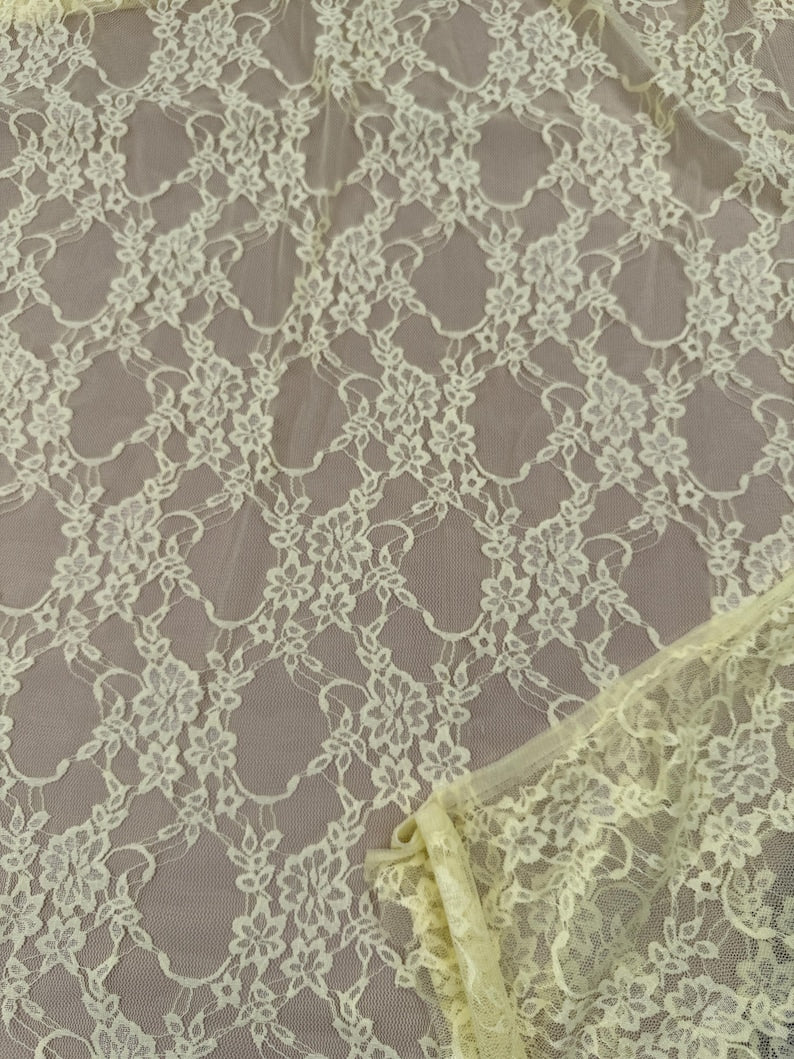 Close up pale yellow lace fabric with intricate floral interconnected design