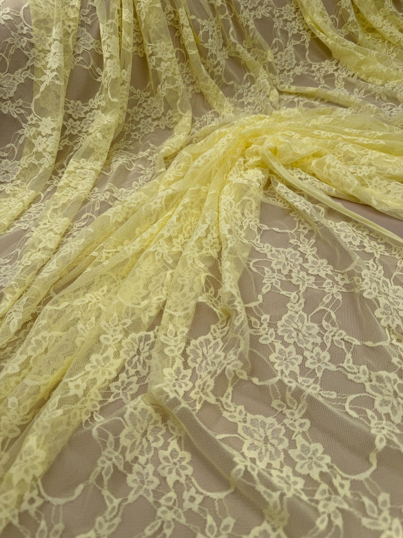 Pale yellow floral lace fabric draped showing full repeating pattern