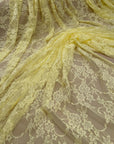 Pale yellow floral lace fabric draped showing full repeating pattern
