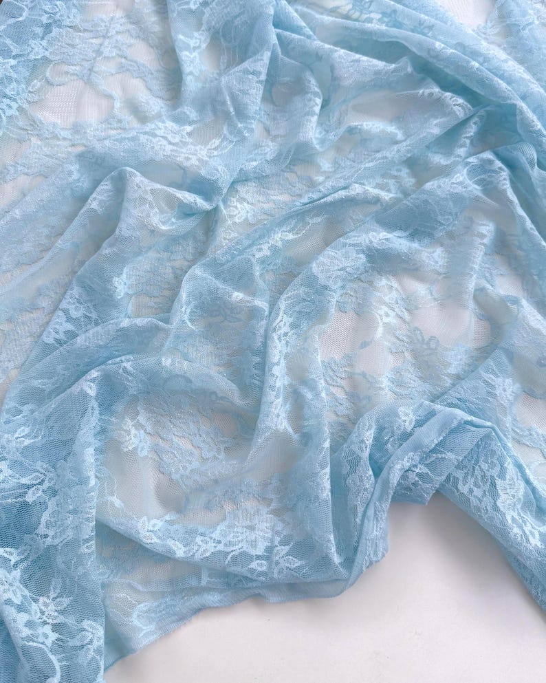 Baby Blue Floral Stretch Lace Fabric draped in airy light blue folds