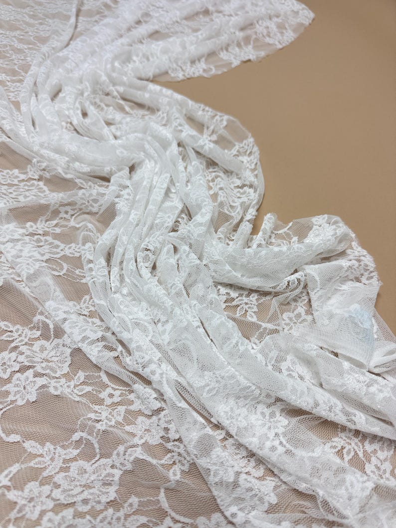 Ivory Floral Stretch Lace Fabric draped and layered showing intricate floral design