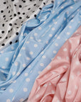 Ivory, dusty blue and dusty pink polka dot satin fabrics side by side