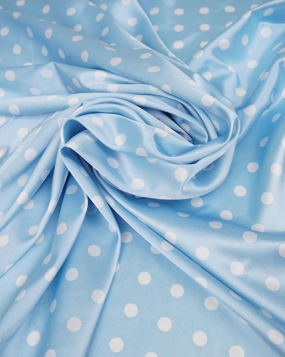 Dusty blue satin fabric with small white polka dots draped in soft folds