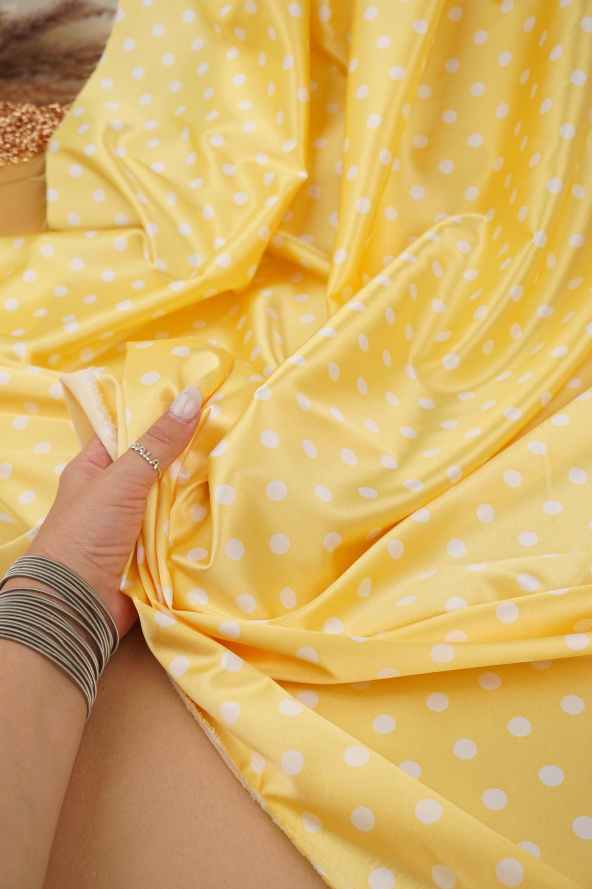 Close-up of yellow satin with small white polka dots