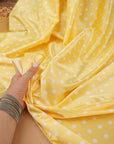 Close-up of yellow satin with small white polka dots