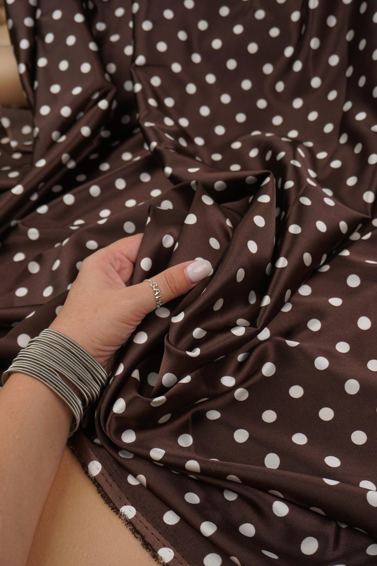 Close-up of chocolate brown satin with small ivory dots