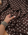 Close-up of chocolate brown satin with small ivory dots