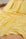 Banana yellow and white polka dot stretch satin fabric draped in soft folds