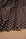 Chocolate brown and ivory polka dot stretch satin fabric draped in soft folds