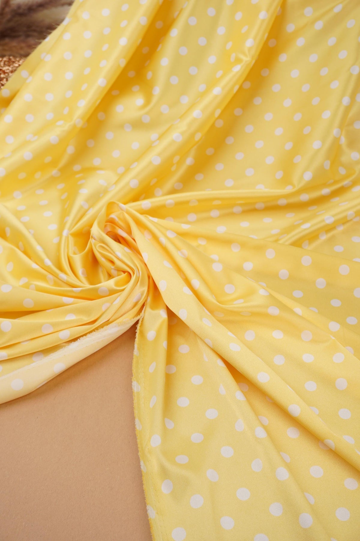 Length of yellow polka dot satin fabric