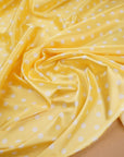 Yellow polka dot satin fabric showing sheen