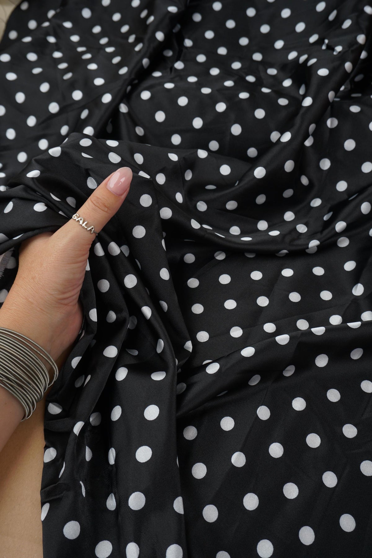 Close-up of black satin with small white polka dots